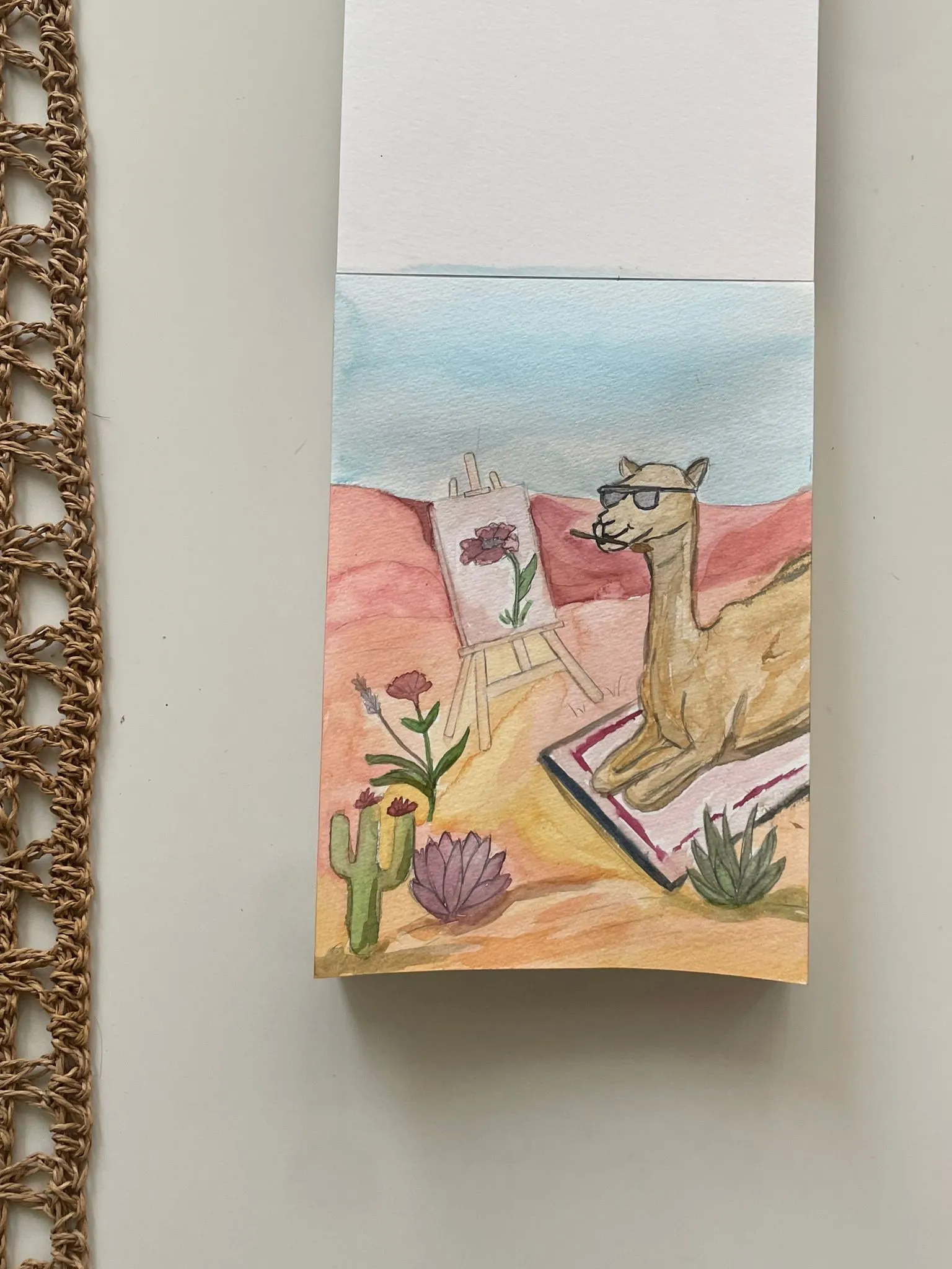 גמל עם משקפי שמש מצייר פרחים במדבר — ציור צבעי מים מאת מיכל